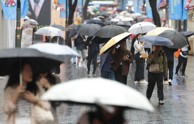 ▲9월 28일 비가 내리는 서울 중구 명동거리에서 시민 및 외국인관광객들이 우산을 쓴 채 걸어가고 있다. (연합뉴스)