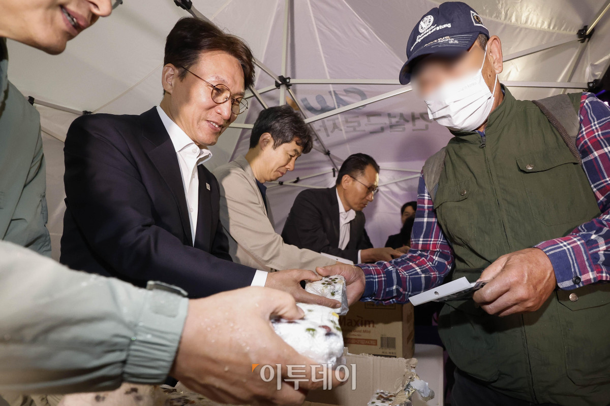 ▲김민석(왼쪽 두 번째) 국무총리가 10일 서울 구로구 남구로역 인근 인력시장을 방문해 건설 일용근로자들에게 간식과 팔토시 등 격려물품을 전달하고 있다. 조현호 기자 hyunho@