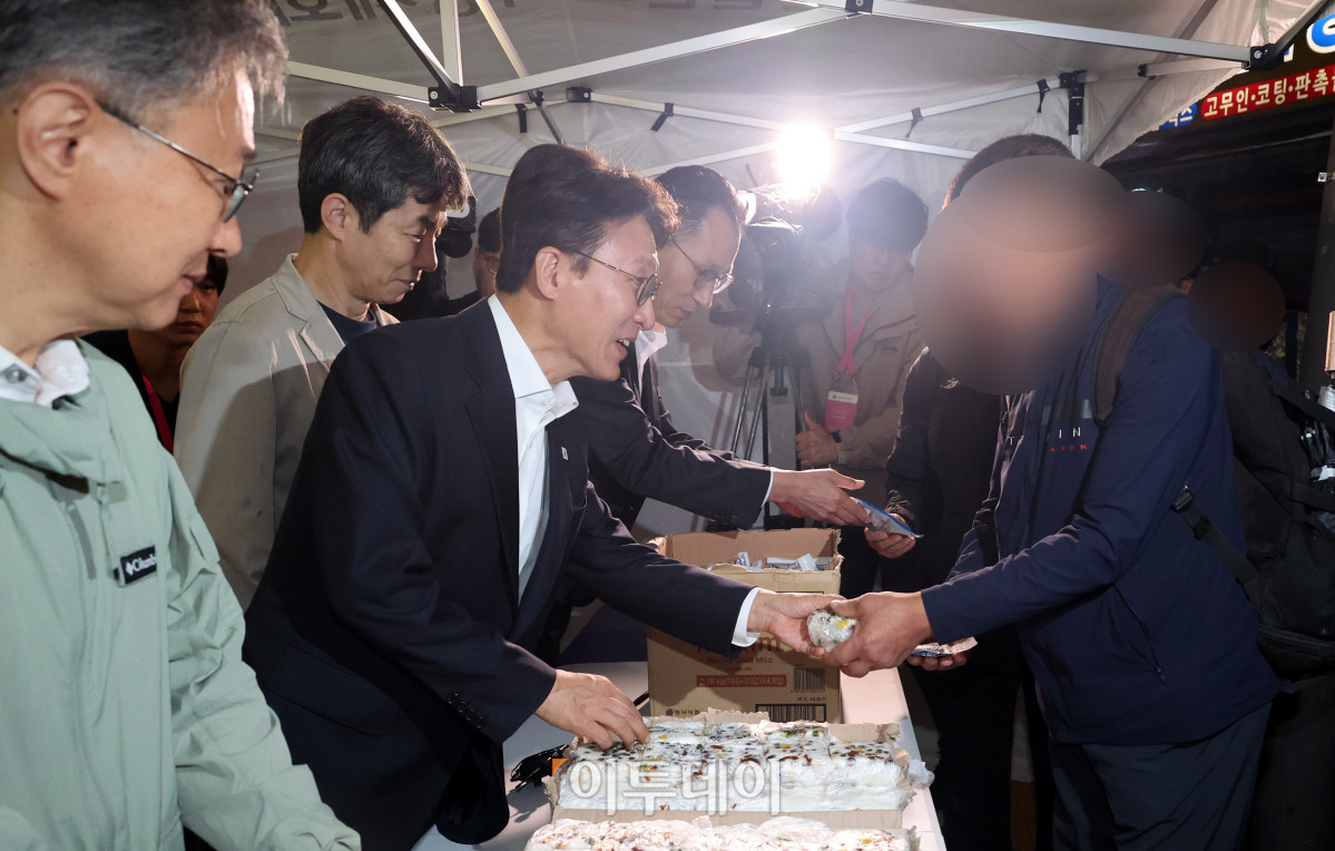 ▲김민석(왼쪽 두 번째) 국무총리가 10일 서울 구로구 남구로역 인근 인력시장을 방문해 건설 일용근로자들에게 간식과 팔토시 등 격려물품을 전달하고 있다. 조현호 기자 hyunho@