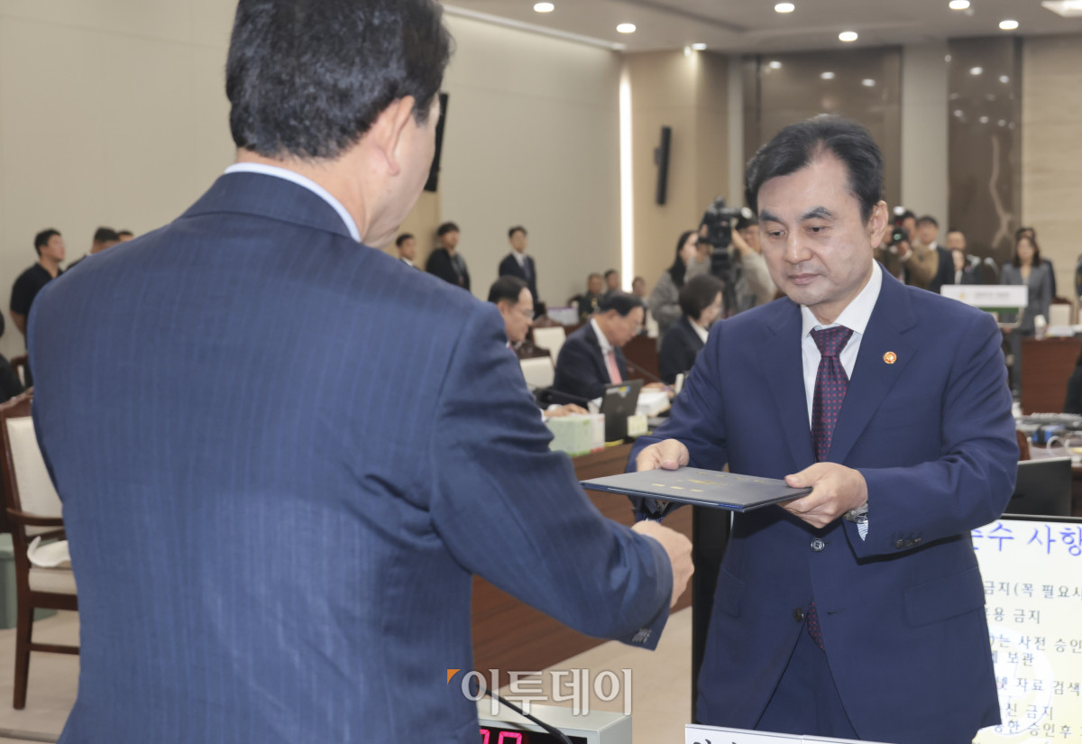 ▲안규백 국방부 장관이 이재명 정부 첫 국정감사가 시작된 13일 서울 용산구 국방부 청사에서 열린 2025 국방부 국정감사에서 선서를 마친 뒤 성일종 국회 국방위원장에게 선서문을 전달하고 있다. 국회사진기자단
