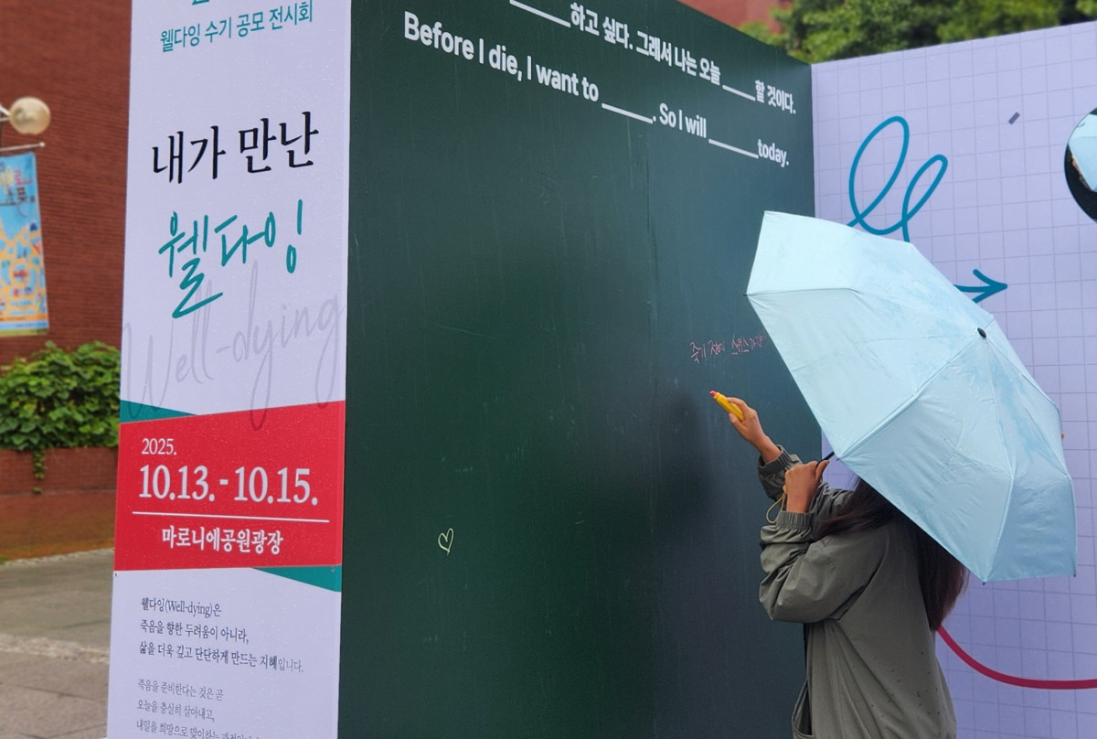 ▲‘Before I die’ 체험존에서 자신의 버킷리스트를 적으며 삶의 의미를 되새기는 관람객.(한국노인종합복지관협회 제공)