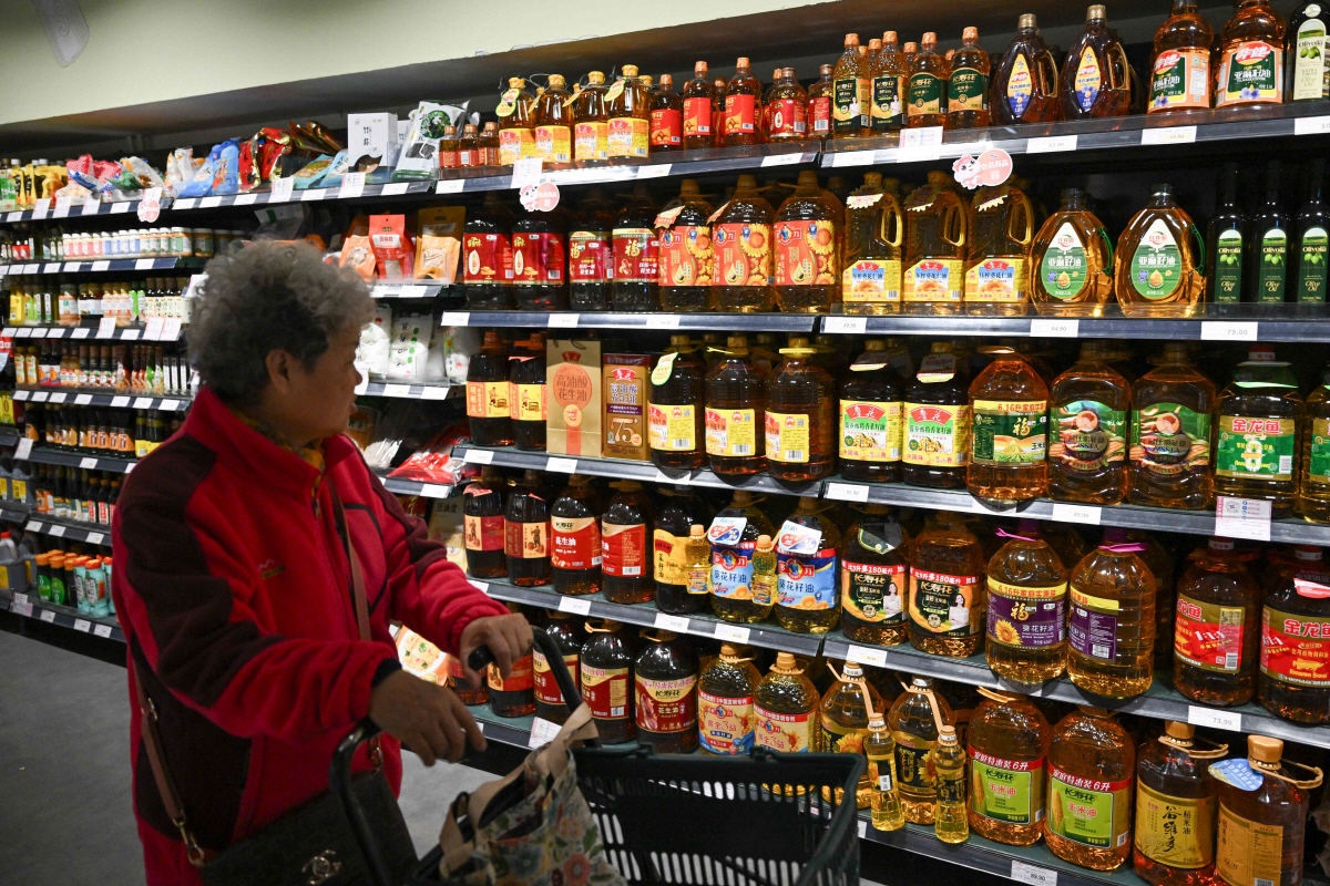 ▲2025년 10월 15일 베이징 한 슈퍼마켓에서 한 소비자가 판매 중인 식용유 진열대를 지나며 둘러보고 있다.  (베이징/AFP연합뉴스)
