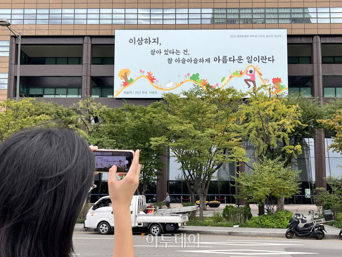 ▲15일 한 시민이 서울 광화문 교보문고 외벽의 글판을 촬영하고 있다. 글판의 내용은 최승자 시인의 ‘20년 후에, 지에게’에서 발췌한 문장이다. 박진희 수습기자 jinhee12@