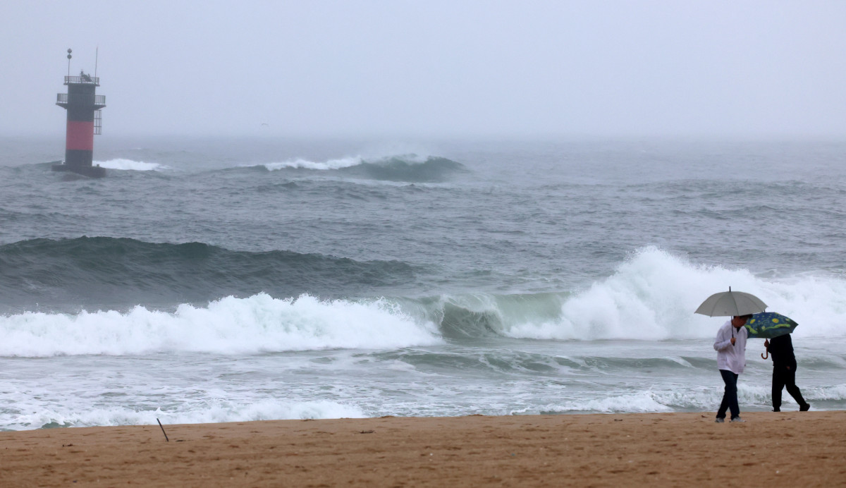 ▲13일 오후 강원 강릉시 경포해수욕장에서 관광객들이 비가 오는 가운데 해변을 걷고 있다. (연합뉴스)