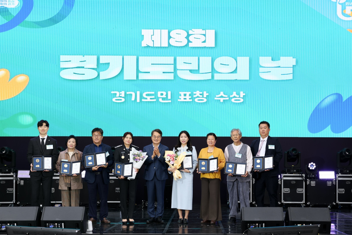 ▲제8회 경기도민의 날 행사에서 경기도민 표창 수상자들이 무대 위에서 상장과 꽃다발을 들고 단체 사진을 찍고 있다. (경기도)