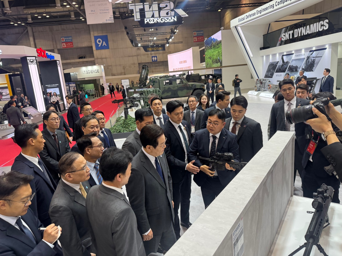 ▲이재명대통령이 snt모티브 부스 방문.(대통령 오른쪽) 특수개발관리담당 손주현 이사가 대통령에게 K13 기관단총에 대해 설명하고 있는 모습. (사진제공=SNT그룹)