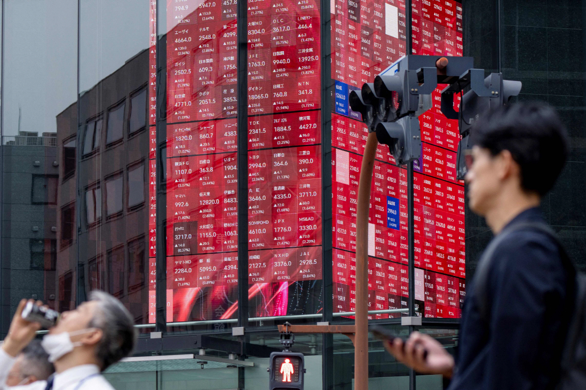 ▲20일 도쿄에서 행인들 뒤로 도쿄 증권거래소의 닛케이지수를 표시하는 전자 주가판이 보인다.  (도쿄/AFP연합뉴스)