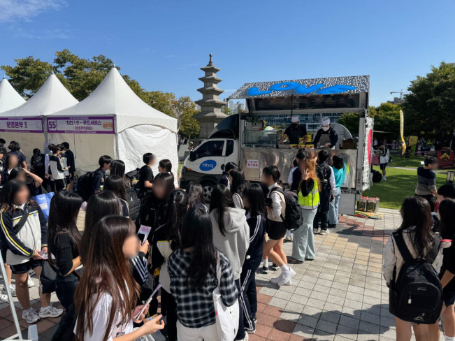 ▲제너시스BBQ 그룹이 17일 이천시청 앞 광장 일대에서 진행된 ‘2025 이천시 청소년진로체험박람회’에서 찾아가는 치킨릴레이를 통해 치킨을 기부했다. (사진제공=BBQ)