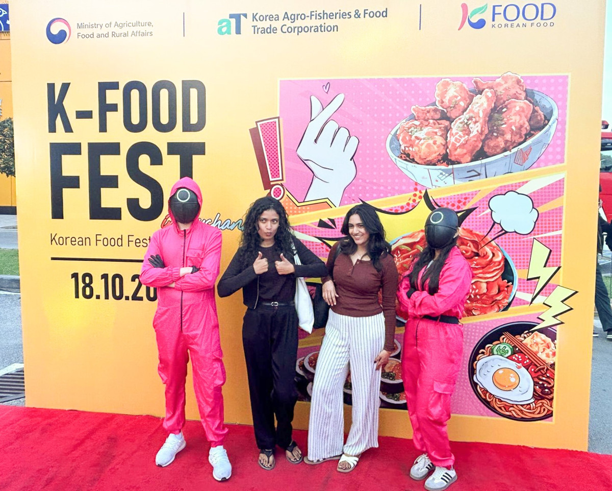 ▲18일 타지키스탄 두샨베에서 열린 ‘2025 K-푸드 페스티벌(Korean Food Festival 2025)’에 참여한 현지인들이 '오징어게임' 코스튬 플레이어와 기념 촬영을 하고 있다. (사진제공=한국농수산식품유통공사)