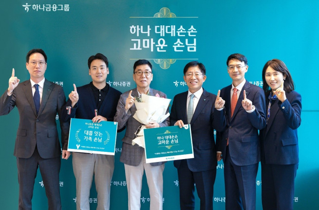 ▲강성묵(오른쪽 세번째) 하나증권 대표와 임직원들이 대대손손 이벤트에 선정된 가족 손님에게 사은품을 전달하고 기념 촬영을 하고 있다. (제공=하나증권)