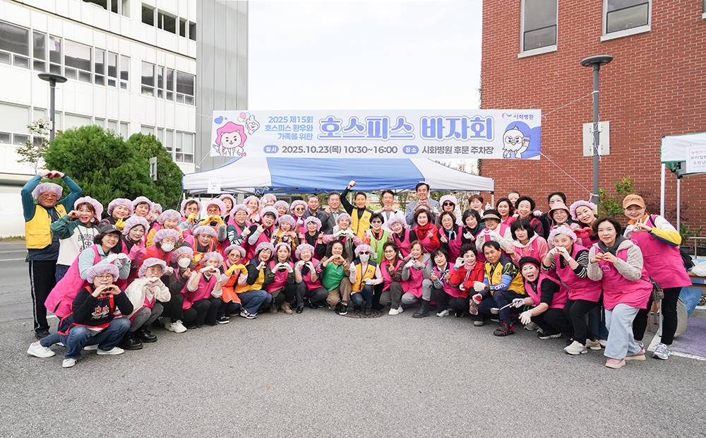 ▲시화병원 관계자들과 자원봉사자들이 23일 병원 후문 주차장에서 열린 호스피스 바자회 행사장에서 단체 사진을 촬영하고 있다. (시화병원)