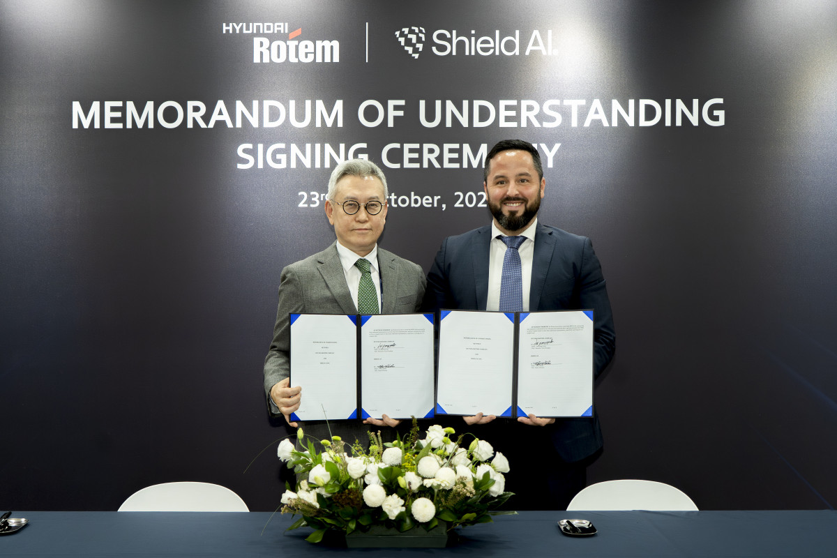 ▲이정엽 현대로템 부사장(왼쪽) 과 마이크 한린 쉴드AI 글로벌 전략 및 사업개발 총괄이 23일 경기 고양시 킨텍스(KINTEX)에서 열린 ‘2025 서울 국제 항공우주 및 방위산업 전시회(ADEX)’에서 ‘국방 AI 기반 다목적 드론 운용 기술 개발을 위한 업무협약’을 체결한 후 기념촬영을 하고 있다. (사진= 현대로템)