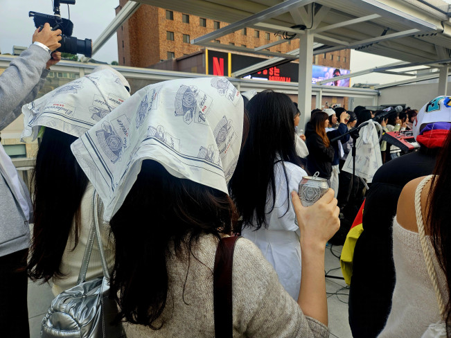 ▲26일 일요일 오전 7~11시 서울 이태원의 한 루프탑 바에서 진행한 버드와이저의 '얼리 버드' 행사 공연을 관람하는 소비자들이 버드와이저 제로 굿즈를 착용하고, 음료를 마시고 있다. (사진=정영인 기자 oin@)