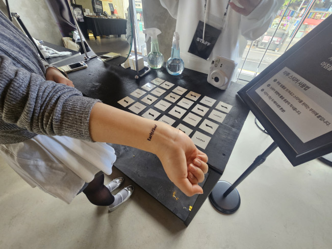 ▲26일 일요일 오전 7~11시 서울 이태원의 한 루프탑 바에서 진행한 버드와이저의 '얼리 버드' 행사에서 오비맥주 관계자가 타투를 체험해보고 있다. (사진=정영인 기자 oin@)