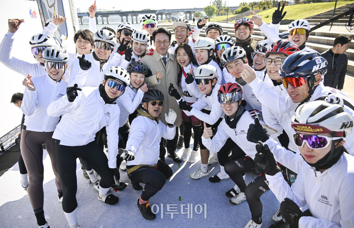 ▲김민석 국무총리가 27일 서울 여의도 한강공원 물빛무대에서 열린 자전거 신(新)조선통신사 행사에서 통신사 대원들과 기념촬영을 하고 있다. 조현호 기자 hyunho@