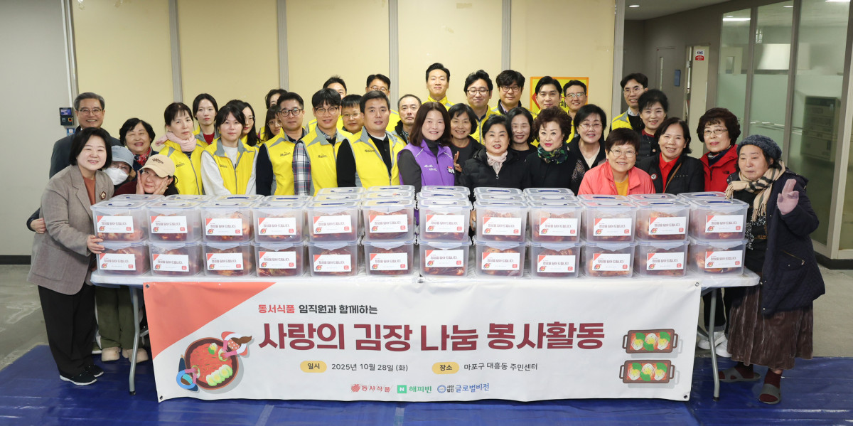 ▲동서식품이 지난 28일 서울시 마포구 대흥동주민센터에서 다문화·한부모 가정과 함께하는 김장 봉사활동을 진행했다. 봉사활동에 참여한 동서식품 직원들이 단체사진을 찍고 있다. (사진제공=동서식품)