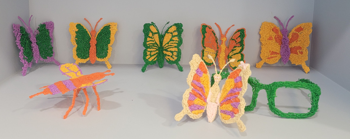 ▲어린이들이 만든 코딩과 3D펜으로 제작한 여러 색상의 나비와 안경 모양 작품이 전시되어 있다. (경기문화재단)