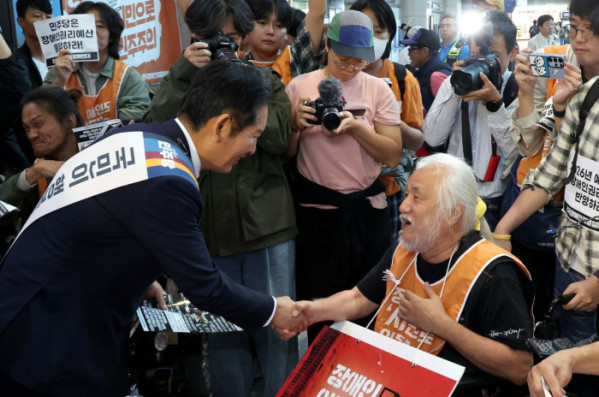 ▲정청래 더불어민주당 대표와 김병기 원내대표를 비롯한 지도부가 2일 서울 용산역에서 전국장애인차별철폐연대(전장연) 관계자들과 인사하고 있다. 신태현 기자 holjjak@