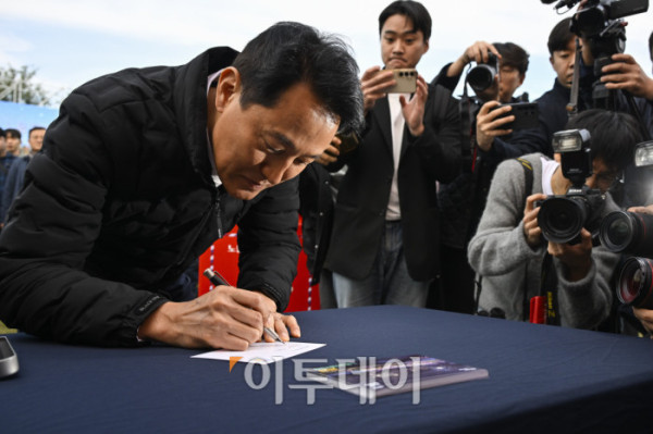 ▲오세훈 서울시장이 21일 서울 용산구 노들섬에서 열린 노들 글로벌 예술섬 착공식에서 느린우체통 엽서를 작성하고 있다. 조현호 기자 hyunho@