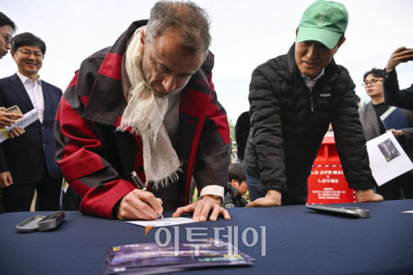 ▲토마스 헤더윅 건축가가 21일 서울 용산구 노들섬에서 열린 노들 글로벌 예술섬 착공식에서 느린우체통 엽서를 작성하고 있다. 오른쪽은 오세훈 서울시장. 조현호 기자 hyunho@