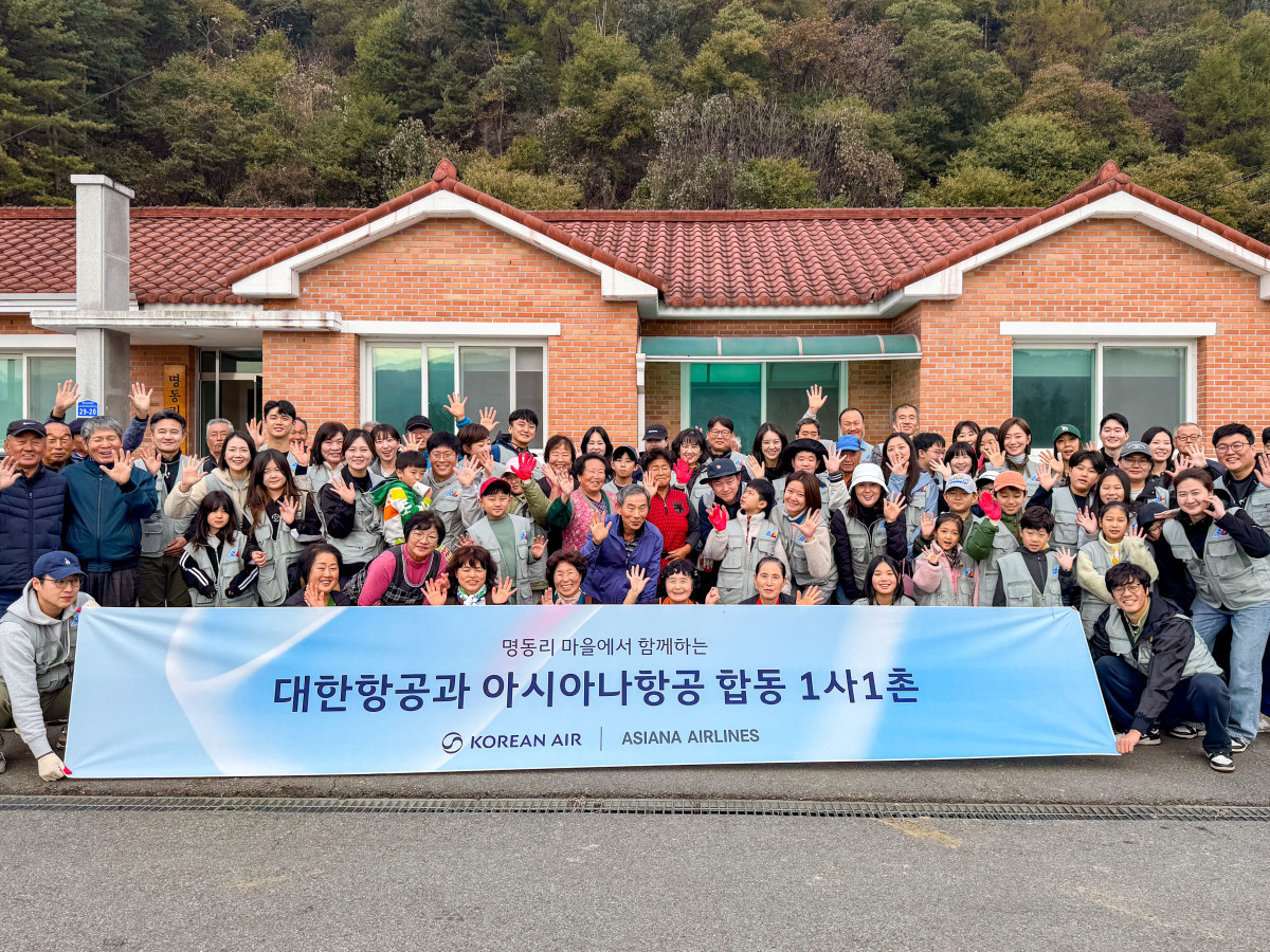 ▲봉사활동에 참여한 대한항공·아시아나항공 양사 임직원과 가족들이 명동리 주민들과 기념사진을 촬영하는 모습. (사진=대한항공)