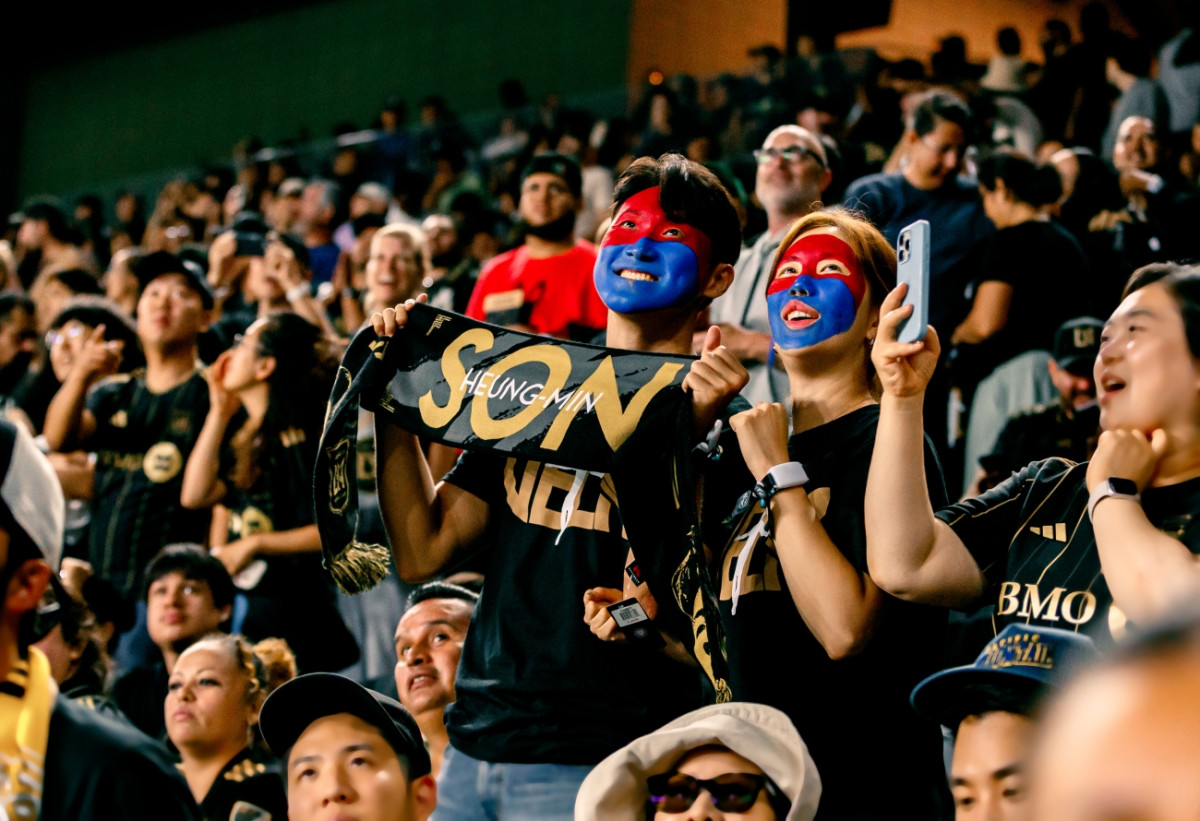 ▲하이브 로고가 새겨진 응원밴드를 손목에 착용한 팬들이 경기를 응원하는 모습.(사진제공=하이브)