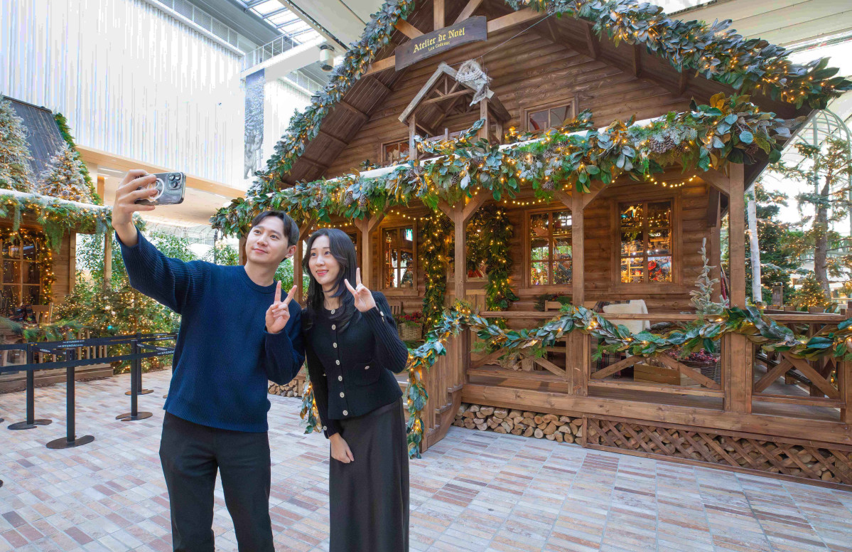 ▲3일 오전 서울 영등포구 더현대 서울 5층 사운즈 포레스트에 조성된 '해리의 크리스마스 공방’에서 고객들이 기념 촬영을 하고 있다. (사진제공=현대백화점)