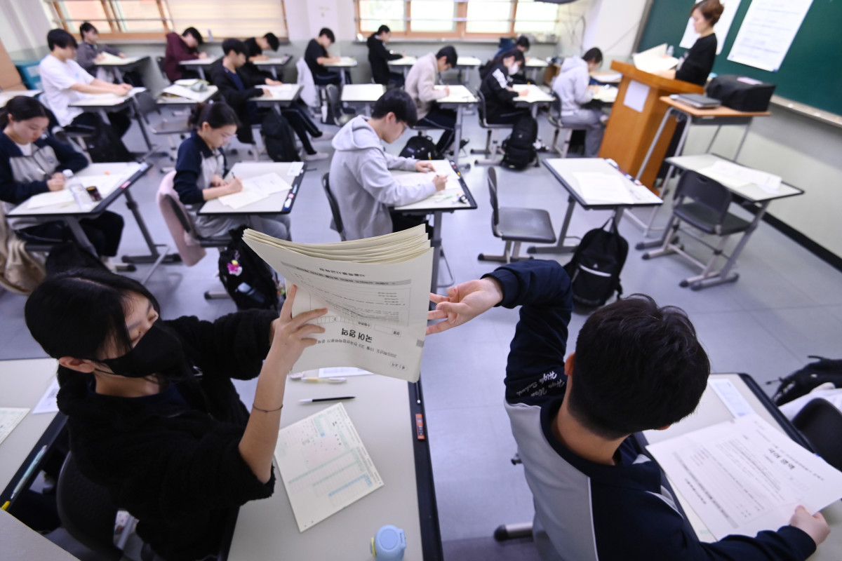 ▲2026학년도 대학수학능력시험을 앞두고 마지막 모의고사인 전국연합학력평가가 실시된 14일 경기 수원시 효원고등학교에서 고3 수험생들이 문제지를 전달하고 있다. (뉴시스)