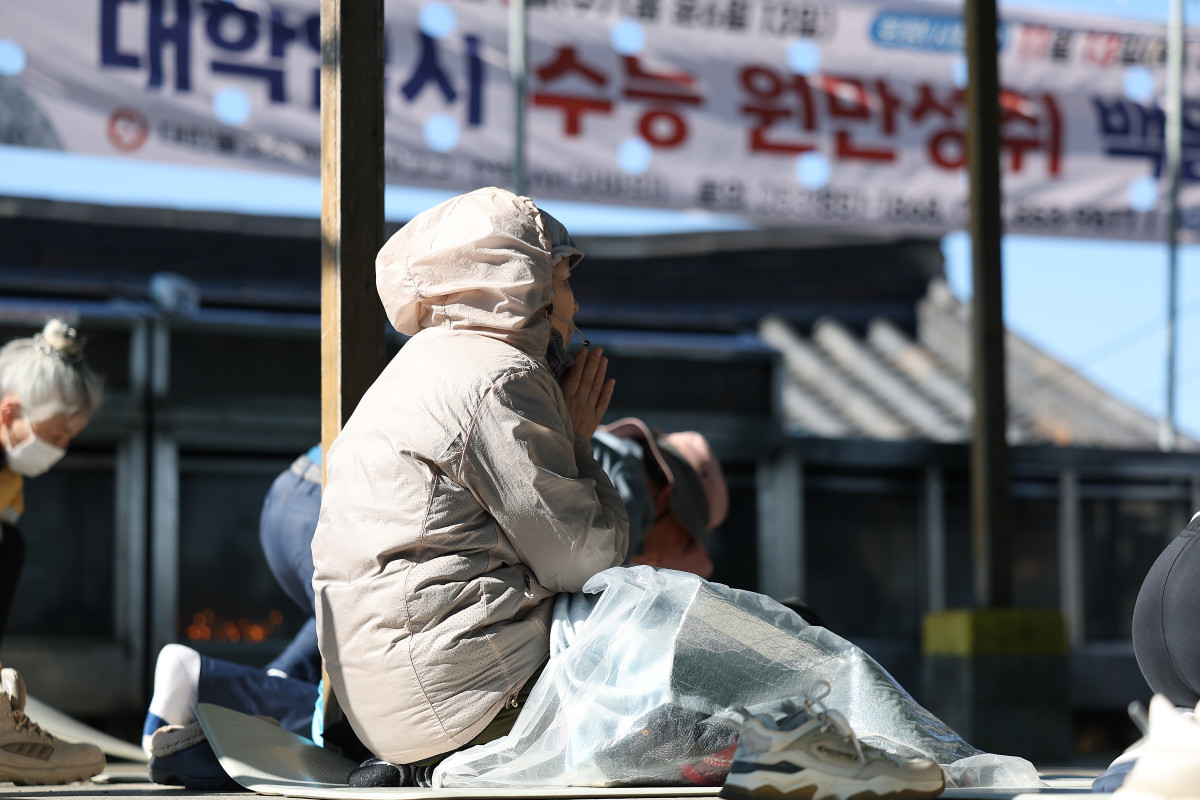 ▲ 2026학년도 대학수학능력시험(수능)을 열흘 앞둔 3일 경북 경산시 팔공산 갓바위에서 한 불자가 두꺼운 옷과 방한용품을 갖추고 기도하고 있다. (사진제공=연합뉴스)