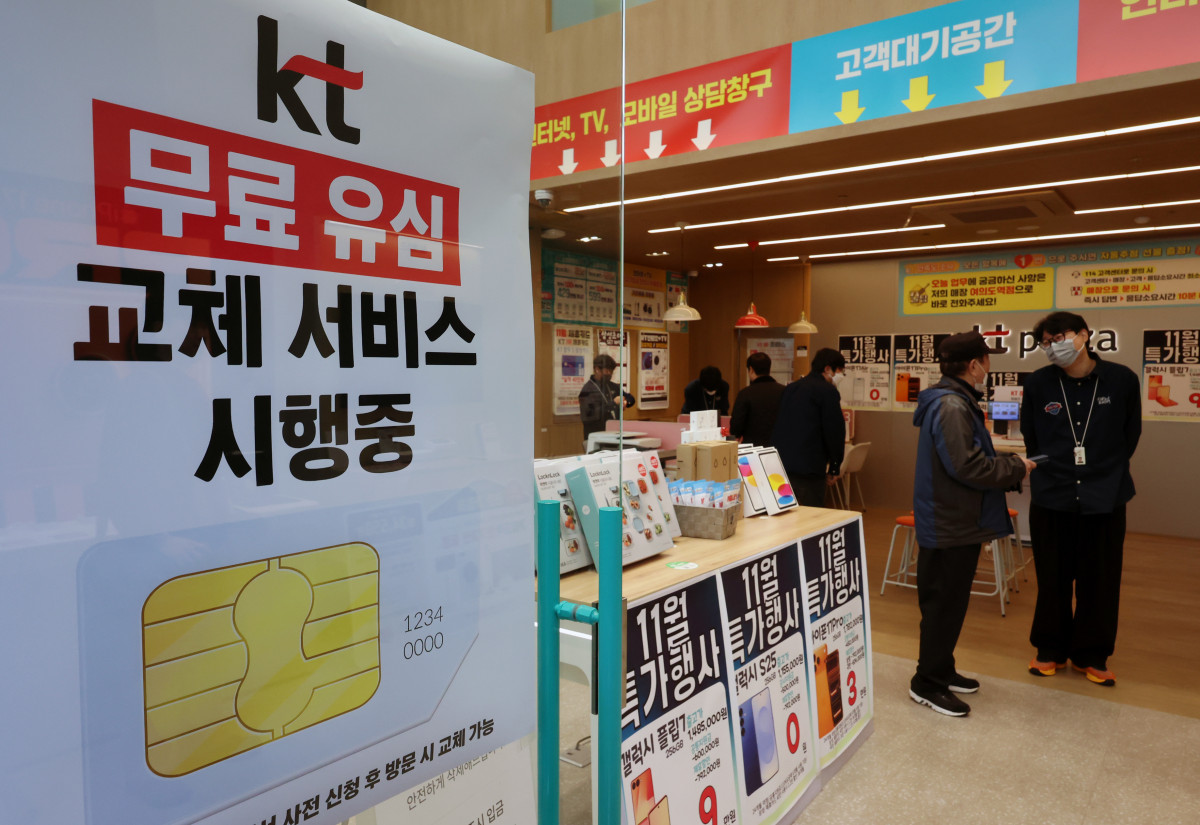 ▲5일 서울의 한 KT 매장에서 고객들이 직원과 상담을 진행하는 가운데, 무료 유심 교체 서비스 시행을 알리는 배너가 설치되어 있다. (뉴시스)