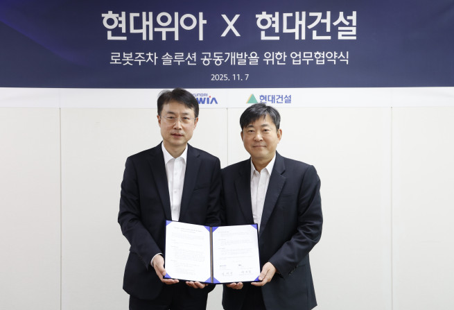 ▲김재영 현대건설 기술연구원 원장(오른쪽)과 백익진 현대위아 모빌리티솔루션사업부 상무가 7일 경기도 의왕시 현대위아 의왕연구소에서 열린 ‘로봇 친화형 주차솔루션 공동개발을 위한 업무협약식’에서 기념 사진을 찍고 있다. (사진제공=현대건설)