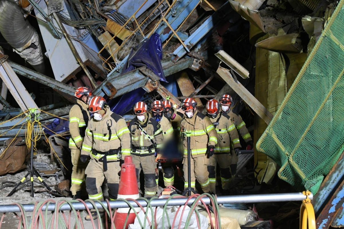▲12일 울산화력발전소 붕괴 현장에서 구조대원들이 수습된 매몰자를 건물 밖으로 이송하고 있다. (연합뉴스)
