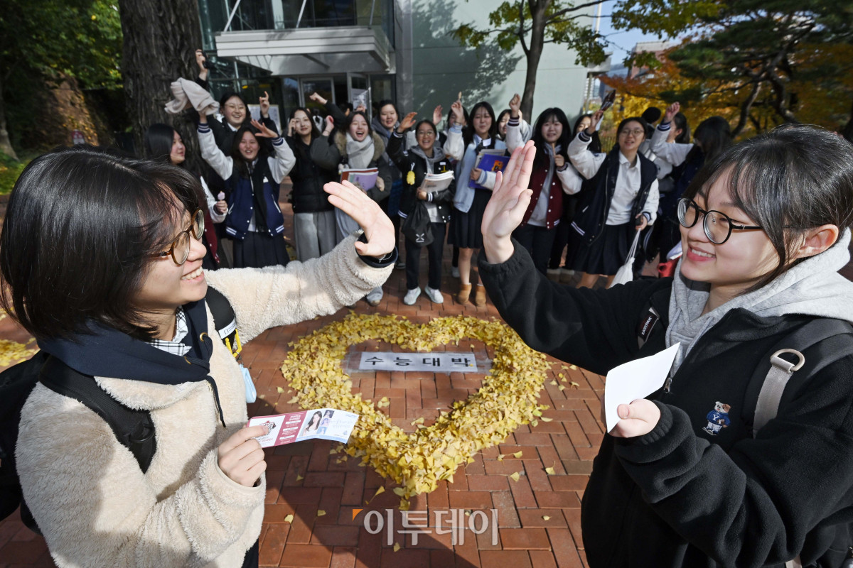 ▲2026학년도 대학수학능력시험을 하루 앞둔 12일 서울 중구 이화여고에서 수험생들이 후배들의 응원을 받으며 하이파이브를 하고 있다. (조현호 기자 hyunho@)