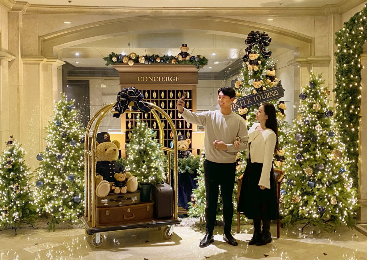 ▲켄싱턴호텔 여의도를 방문한 커플이 크리스마스 트리를 배경으로 기념 촬영을 하고 있다. (사진제공=이랜드파크)