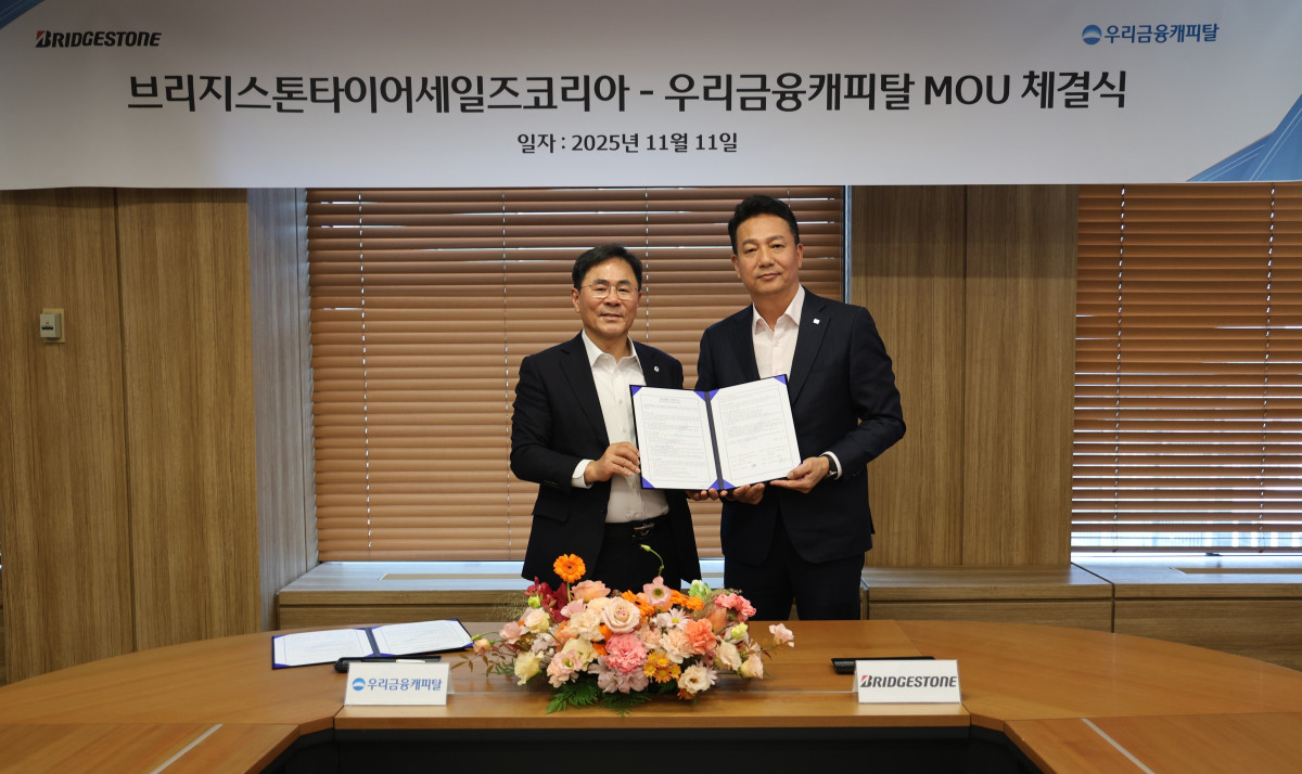 ▲기동호(왼쪽) 우리금융캐피탈 대표이사와 김헌영 브리지스톤타이어세일즈코리아 대표이사가 11일 화물차주 상생 금융지원 업무협약을 체결한 후 기념사진을 촬영하고 있다. (사진제공=우리금융캐피탈)