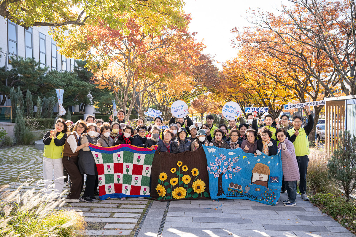 ▲JB금융그룹 전북은행지역사랑봉사단이 전북은행 본점 앞 가로수 길에서 금암노인복지관과 함께 가로수 ‘그래피티 니팅’ 봉사활동을 실시했다. (사진제공=전북은행)