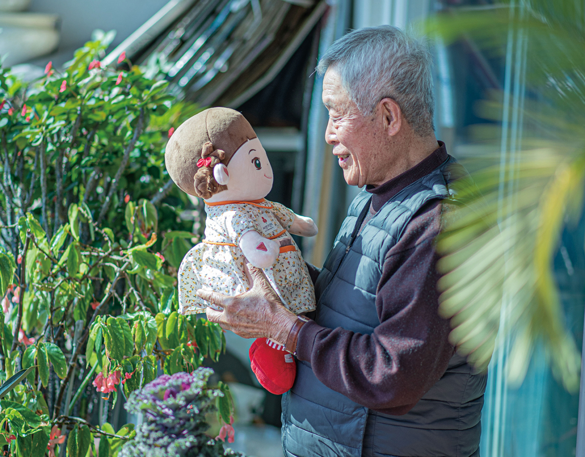▲돌봄로봇 효돌을 품에 안은 채 이야기를 건네며 정서적 교감을 나누는 고령 사용자의 모습.(효돌 제공)