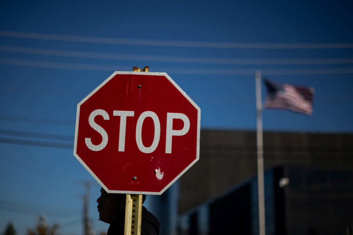 ▲미국 일리노이주 시카고 브로드뷰 ICE 시설 밖에서 한 시위자가 교통 정지 표지판 옆에 있다.  (시카고(미국)/로이터연합뉴스)