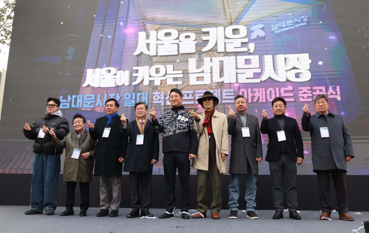 ▲17일 서울 중구 남대문시장 일대에서 열린 ‘남대문시장 아케이드 조성 준공식’에서 오세훈(왼쪽에서 다섯번 째) 서울시장과 김길성 중구청장 등이 기념촬영을 하고 있다. 남대문시장 중심가로 약 135m 구간에 조성된 아케이드는 한옥 처마를 형상화했다. 신태현 기자 holjjak@