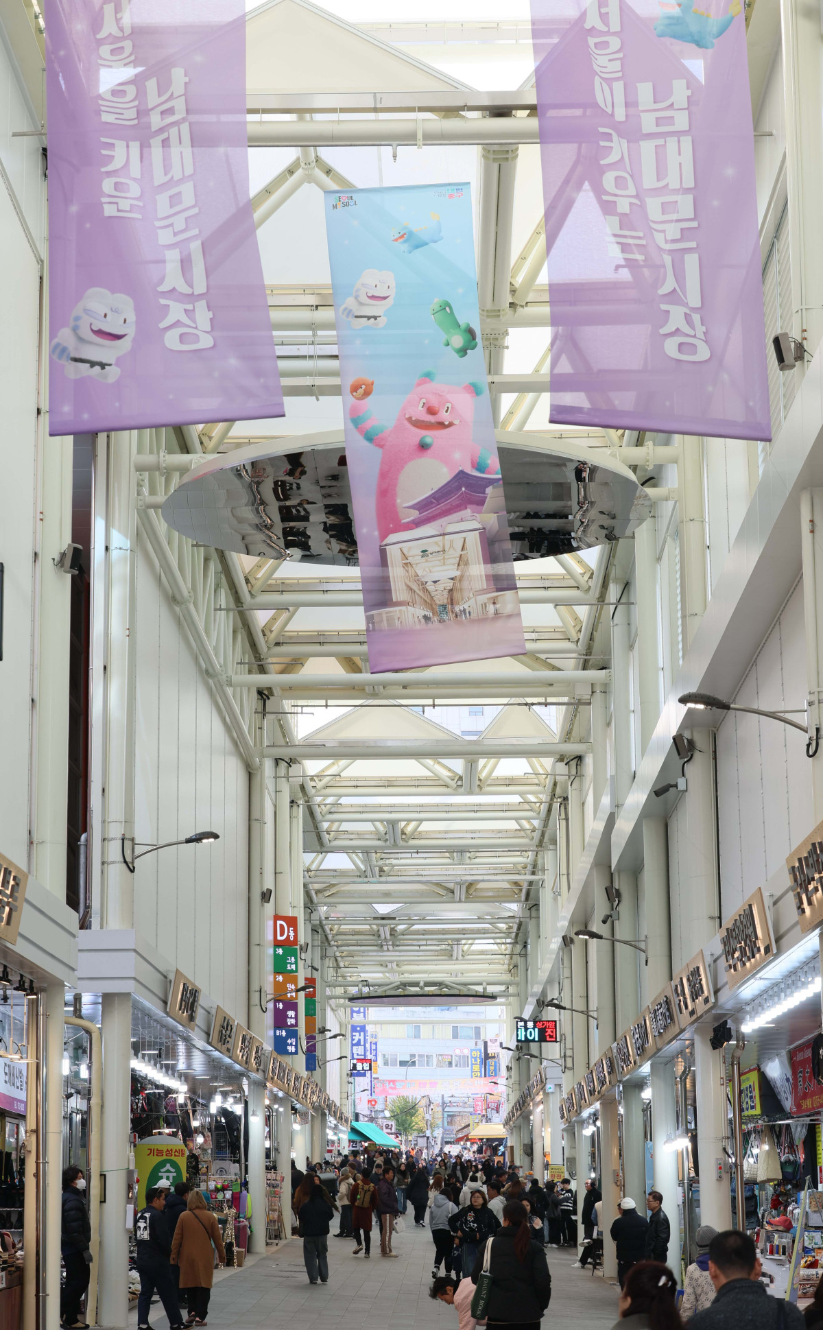 ▲17일 서울 중구 남대문시장에서 시민들이 아케이드 아래를 지나고 있다. 서울시는 이날 ‘남대문시장 아케이드 조성 준공식’을 가졌다. 남대문시장 중심가로 약 135m 구간에 설치된 아케이드는 한옥 처마를 형상화했다. 신태현 기자 holjjak@