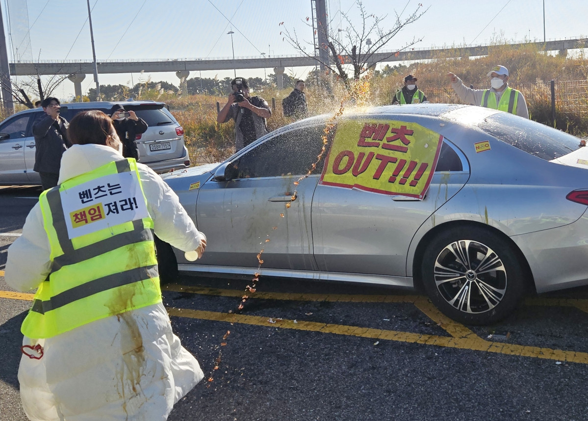 ▲청라 피해대책위원회 주민이 벤츠 차량에 계란을 던지고 있다. (연합뉴스)