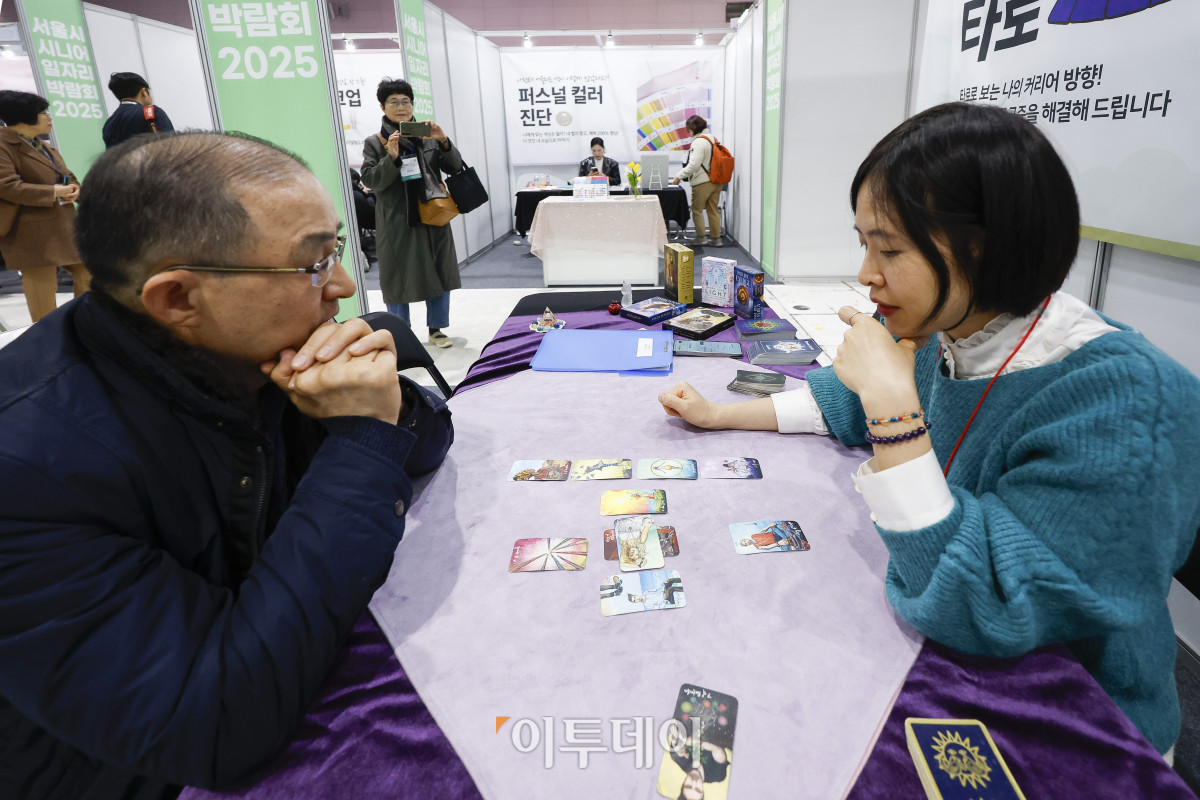 ▲18일 서울 강남구 서울무역전시장(SETEC)에서 열린 서울시 시니어 일자리박람회 2025에서 한 구직자가 취업 타로를 보고 있다. 노인 인력의 사회활동 촉진과 양질의 일자리 확대를 위해 열린 이번 일자리박람회는 고령화 시대의 핵심 인력인 장·노년이 보유한 경력과 전문성을 바탕으로 새로운 일과 삶을 설계하는 것을 지원하기 위해 기획됐다. 채용관·내일 설계관·디지털 혁신 체험관 등으로 구성된 박람회는 71개 기업이 참여해 채용 상담과 면접을 진행한다. 조현호 기자 hyunho@