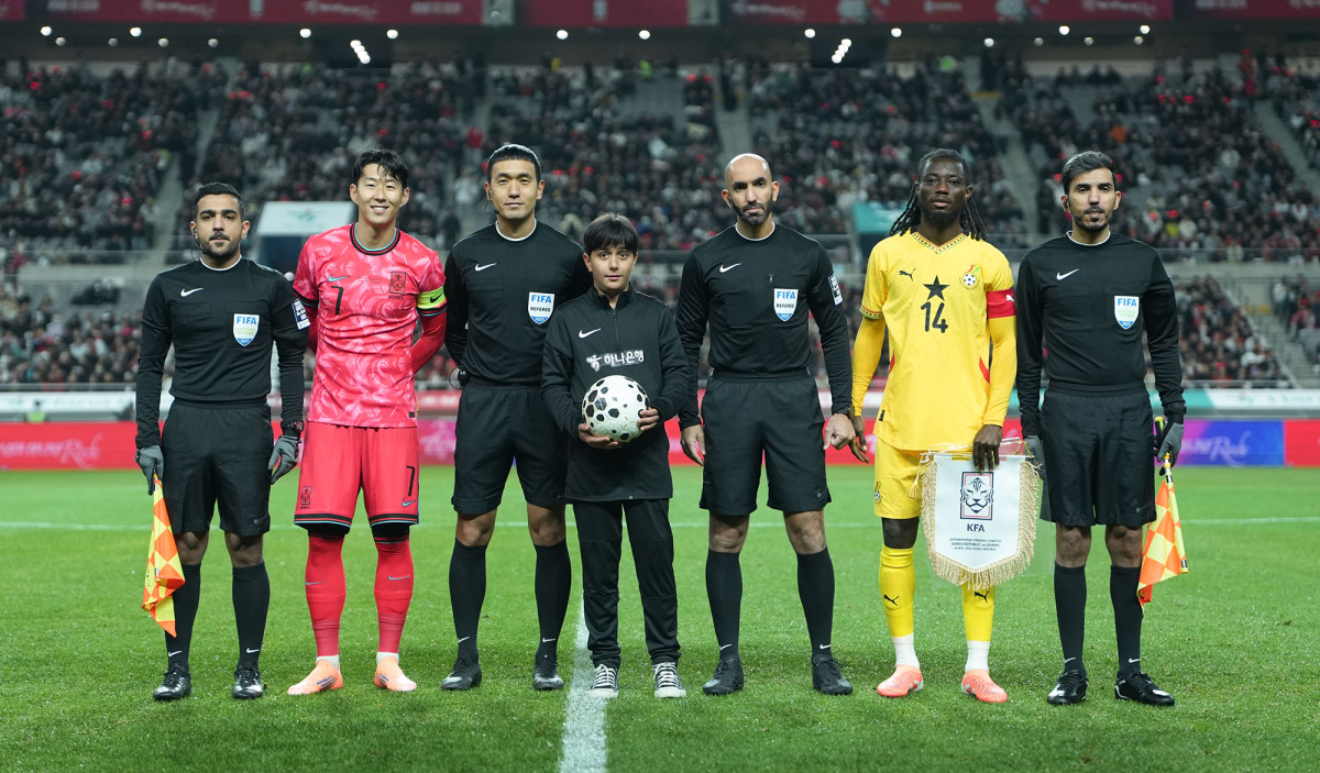 ▲ 18일 서울월드컵경기장에서 열린 대한민국과 가나의 축구 국가대표팀 A매치 경기 시작에 앞서 아프가니스탄 출신 '매치볼 키드' 마시(사진 가운데)가 양 팀 주장 및 심판진과 함께 기념촬영을 하고 있다. (사진제공=하나은행)