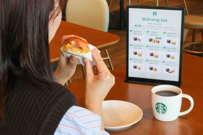 ▲스타벅스 고객이 '모닝 세트'로 구입한 '베이컨 체다 & 오믈렛 샌드위치'와 '카페 아메리카노'를 즐기고 있다. (사진제공=스타벅스 코리아)