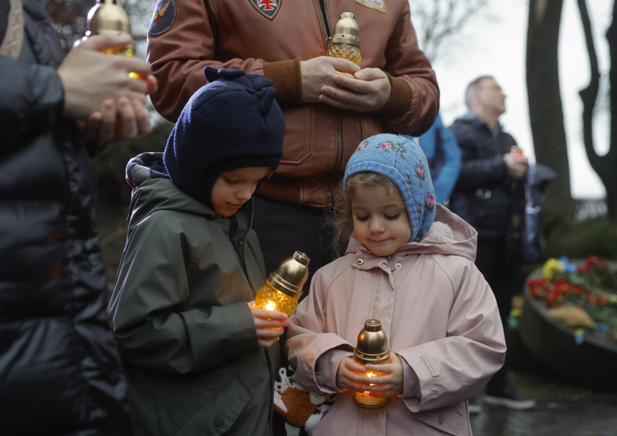 ▲우크라이나 아이들이 22일(현지시간) 국립 홀로도모르 박물관 추모 시설에서 추모 기도를 올리고 있다. (키이우/EPA연합뉴스)