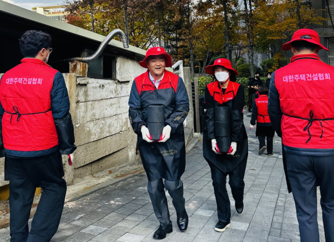 ▲정원주 대한주택건설협회장이 21일 서울 동작구 동작대로 일대에서 사랑의 연탄나눔 봉사활동을 하고 있다. (사진제공=대한주택건설협회)