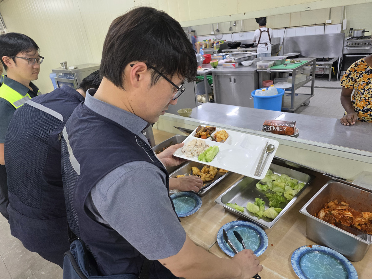 ▲HEC가 호니아라 티나 캠프에 마련한 컨테이너 한식당에서 K-water 직원이 식판을 채우고 있다. (정호영 기자)