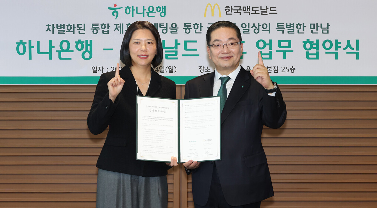▲이호성(사진 오른쪽) 하나은행장과 김기원 한국맥도날드 대표이사가 24일 서울시 중구 을지로 소재 하나은행 본점에서 글로벌 외식 브랜드 맥도날드 코리아와 생활금융 서비스 확대를 위한 업무협약을 맺고 기념 촬영을 하고 있다. (사진제공=하나은행)