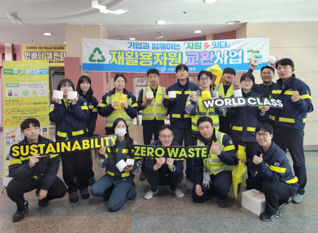 ▲24일 오비맥주 청주공장에서 임직원들이 재활용자원 교환사업에 참여하고 기념사진을 찍고 있다. (사진제공=오비맥주)