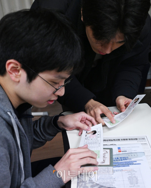 ▲2026학년도 대학수학능력시험을 하루 앞둔 12일 서울 종로구 중앙고등학교에서 고3 수험생들이 수험표를 살펴보고 있다. 조현호 기자 hyunho@